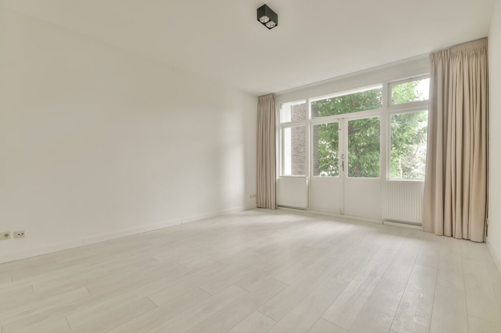 Spacious room with a large windows and door outside